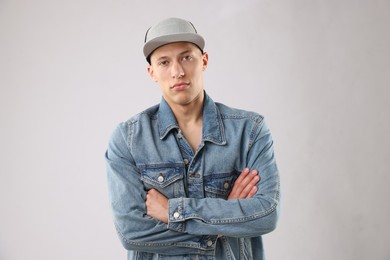 Photo of Young man in stylish baseball hat on light grey background