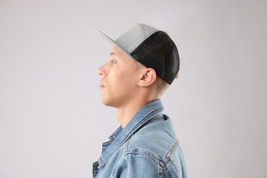 Photo of Young man in stylish baseball hat on light grey background