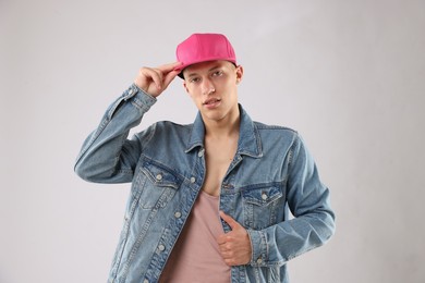 Photo of Young man in stylish baseball hat on light grey background