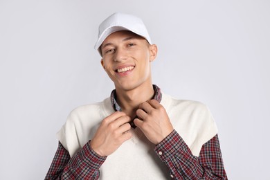 Photo of Young man in stylish baseball hat on light grey background