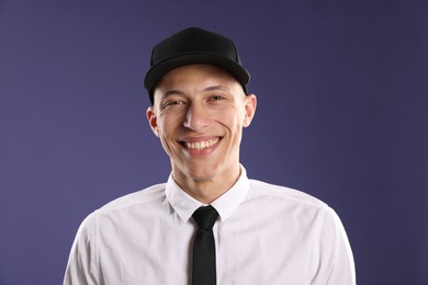 Photo of Young man in stylish baseball hat on dark blue background