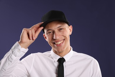 Photo of Young man in stylish baseball hat on dark blue background