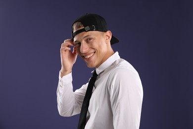 Photo of Young man in stylish baseball hat on dark blue background