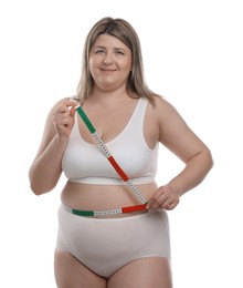 Photo of Weight loss. Plus size woman measuring waist with tape on white background