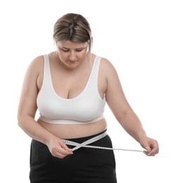 Photo of Weight loss. Plus size woman measuring waist with tape on white background