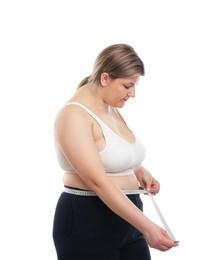 Photo of Weight loss. Plus size woman measuring waist with tape on white background