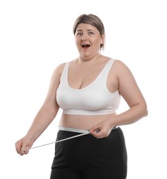 Photo of Weight loss. Emotional plus size woman measuring waist with tape on white background