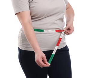 Photo of Weight loss. Plus size woman measuring waist with tape on white background, closeup