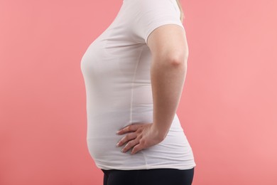 Photo of Weight loss. Plus size woman on pink background, closeup. Space for text