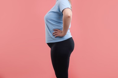 Photo of Weight loss. Plus size woman on pink background, closeup