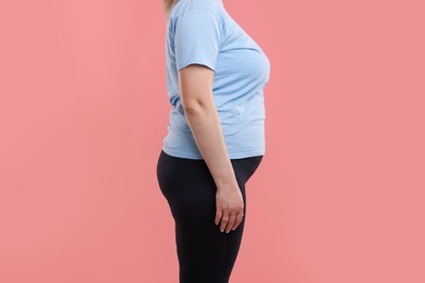 Photo of Weight loss. Plus size woman on pink background, closeup