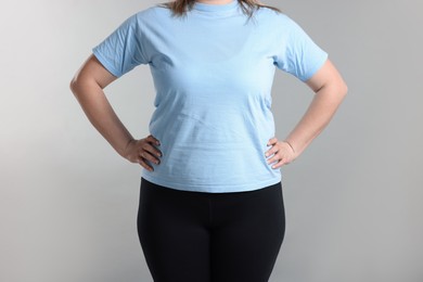 Photo of Weight loss. Plus size woman on gray background, closeup