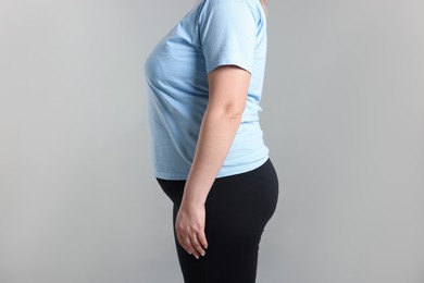 Photo of Weight loss. Plus size woman on gray background, closeup
