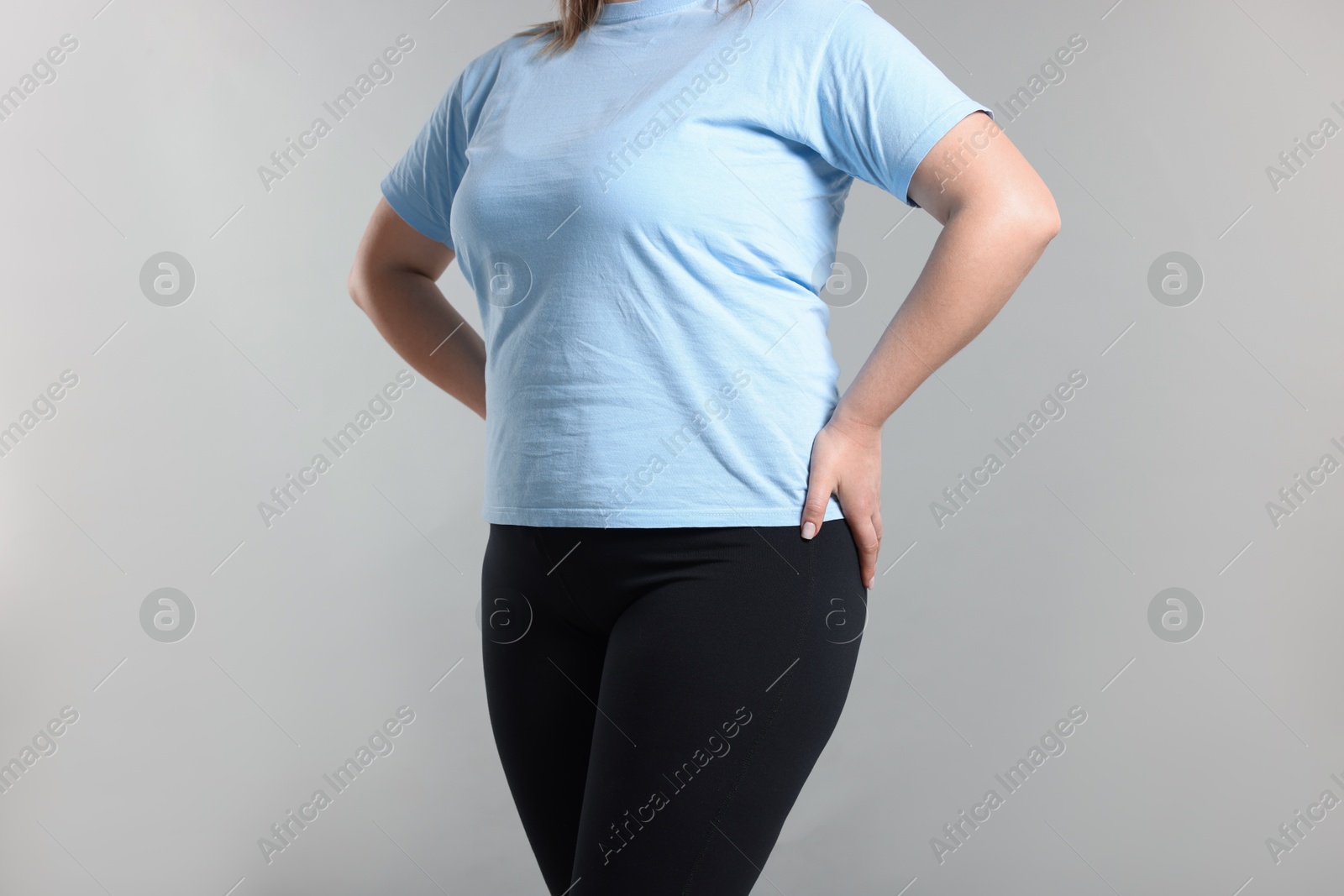 Photo of Weight loss. Plus size woman on gray background, closeup