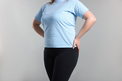 Photo of Weight loss. Plus size woman on gray background, closeup