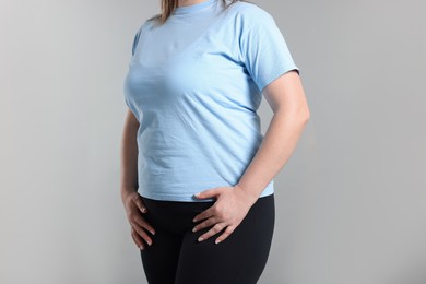 Photo of Weight loss. Plus size woman on gray background, closeup