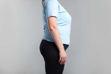 Photo of Weight loss. Plus size woman on gray background, closeup