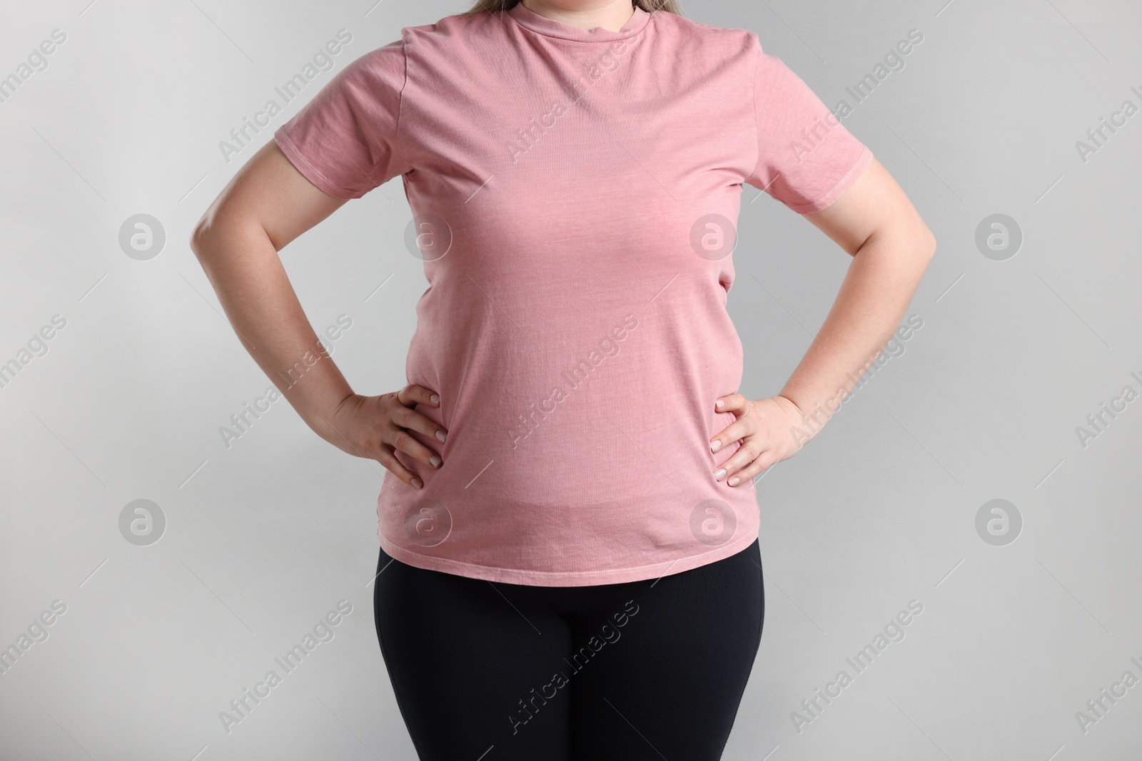 Photo of Weight loss. Plus size woman on gray background, closeup