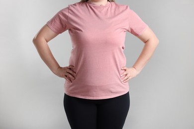 Photo of Weight loss. Plus size woman on gray background, closeup