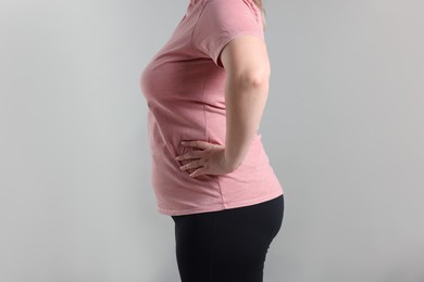 Photo of Weight loss. Plus size woman on gray background, closeup