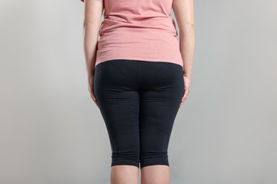 Photo of Weight loss. Plus size woman on gray background, closeup