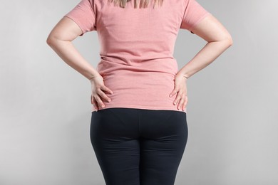 Photo of Weight loss. Plus size woman on gray background, closeup