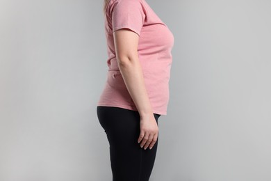 Photo of Weight loss. Plus size woman on gray background, closeup