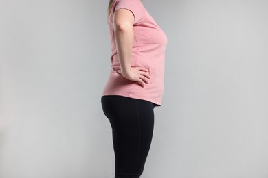 Photo of Weight loss. Plus size woman on gray background, closeup