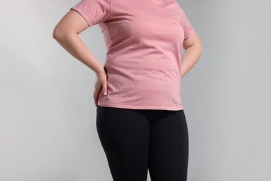Photo of Weight loss. Plus size woman on gray background, closeup