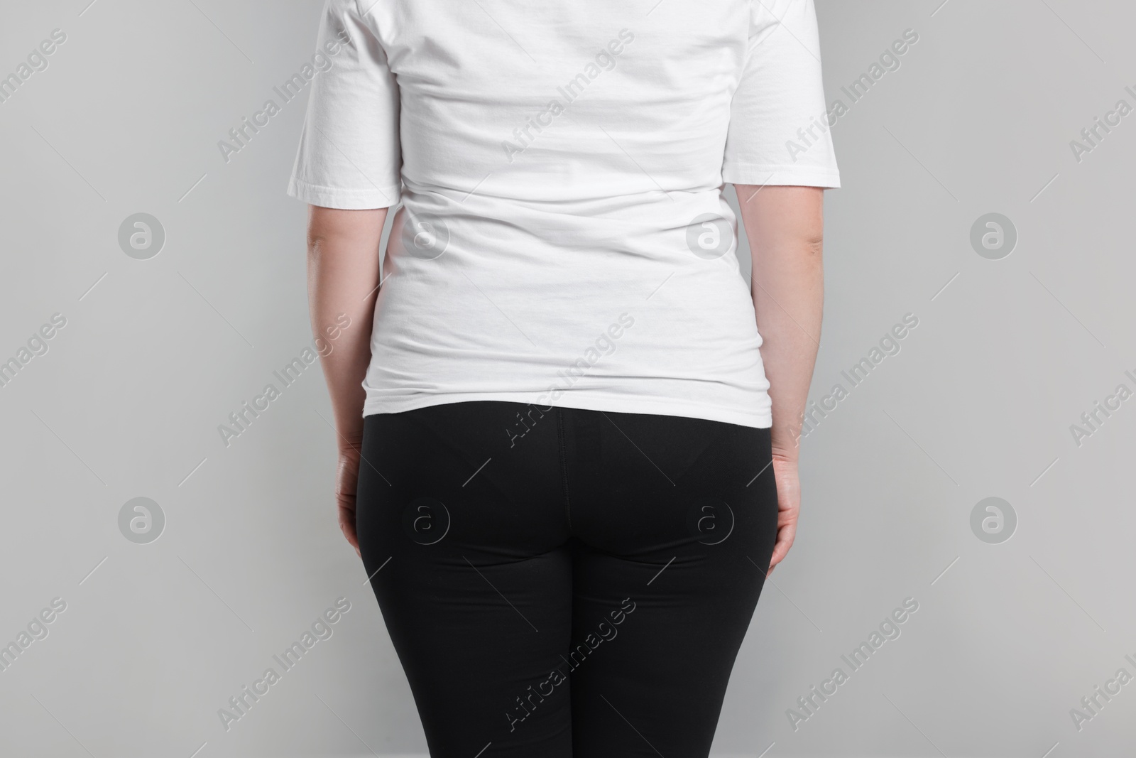 Photo of Weight loss. Plus size woman on gray background, closeup