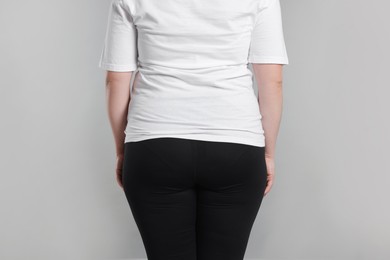 Photo of Weight loss. Plus size woman on gray background, closeup