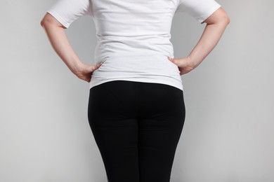 Photo of Weight loss. Plus size woman on gray background, closeup