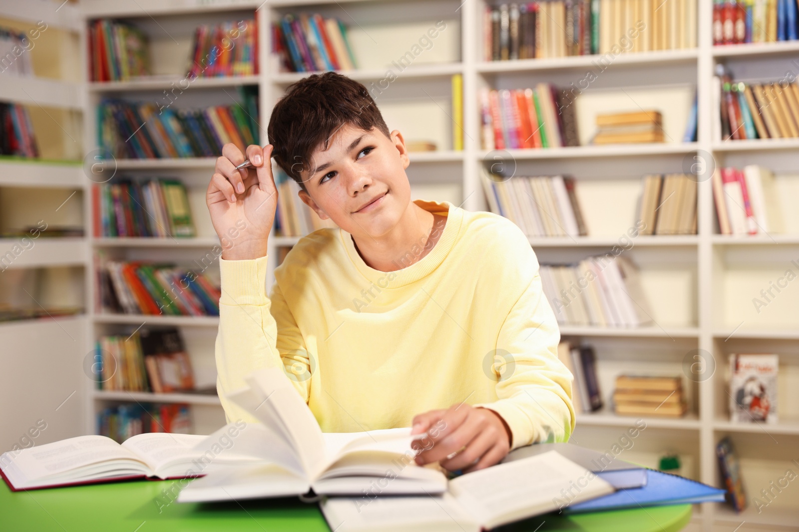 Student with books studying at table in library Photo of Student with books studying at table in library