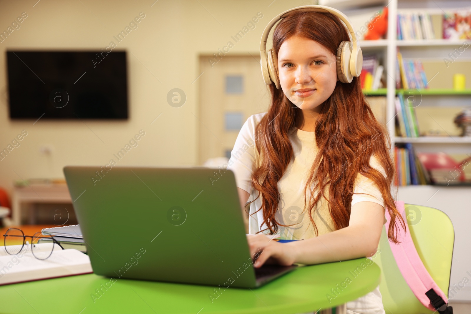 Student with laptop studying at table in library Photo of Student with laptop studying at table in library