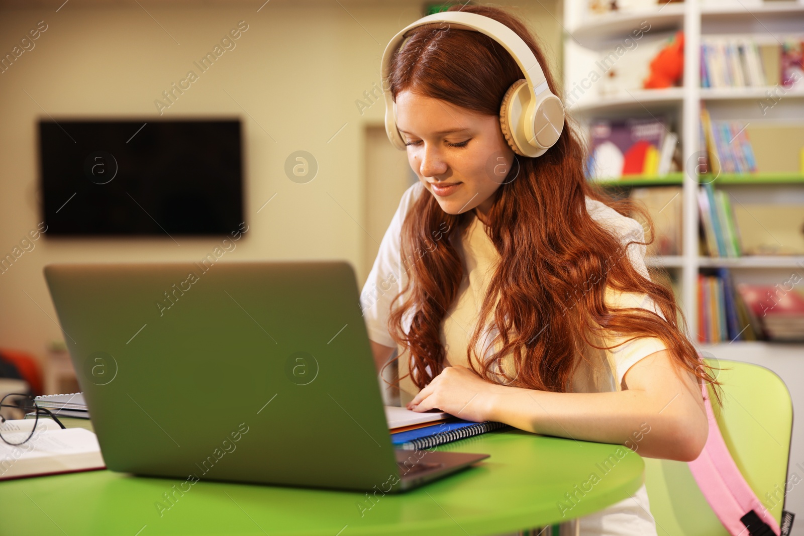 Student with laptop studying at table in library Photo of Student with laptop studying at table in library