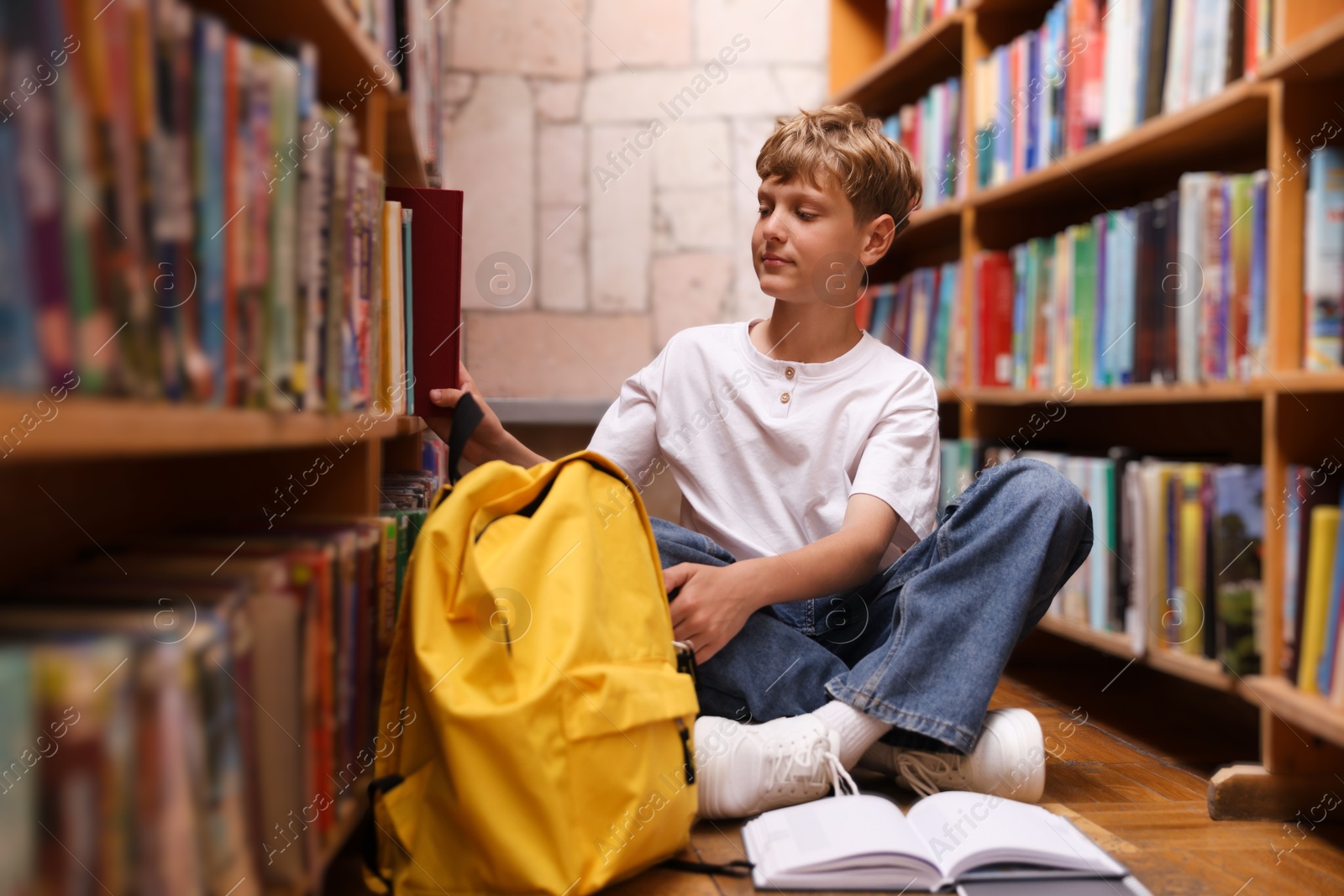 Student taking book out of shelf in library Photo of Student taking book out of shelf in library