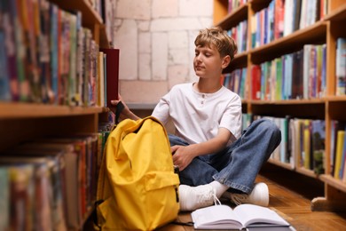 Photo of Student taking book out of shelf in library