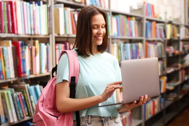Photo of Student with laptop and backpack in library