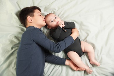 Photo of Cute little brothers on bed, above view