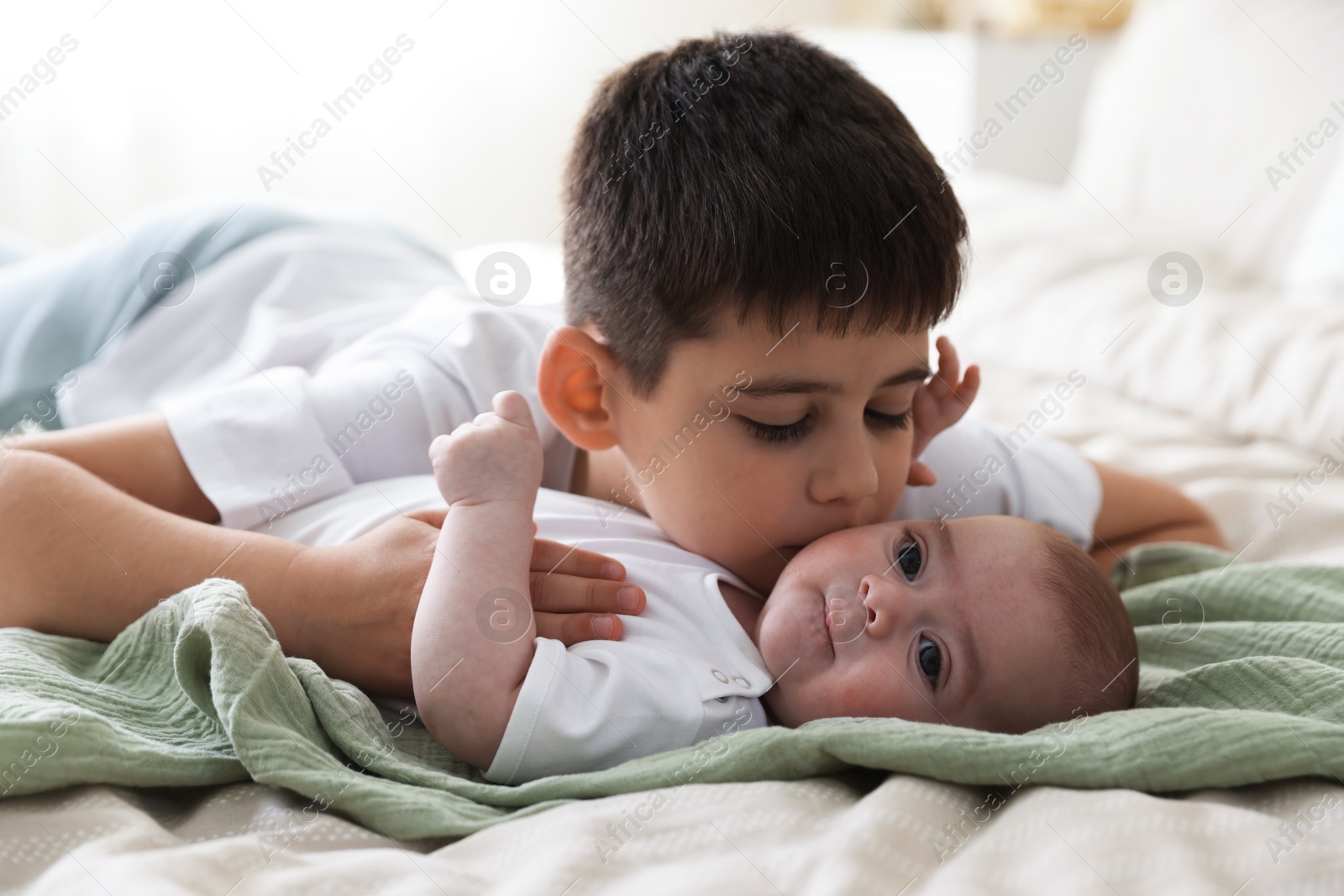 Photo of Cute little brothers on bed at home
