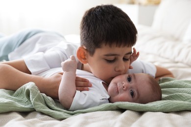 Photo of Cute little brothers on bed at home