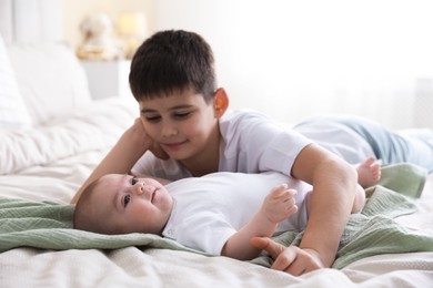 Photo of Cute little brothers on bed at home