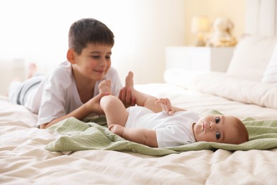 Photo of Cute little brothers on bed at home