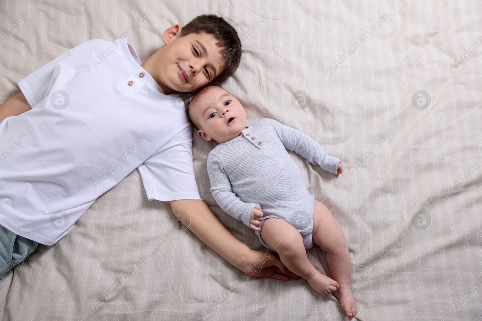 Cute little brothers on bed, top view Photo of Cute little brothers on bed, top view