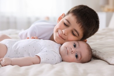 Photo of Cute little brothers on bed at home, closeup