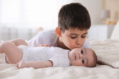 Photo of Cute little brothers on bed at home