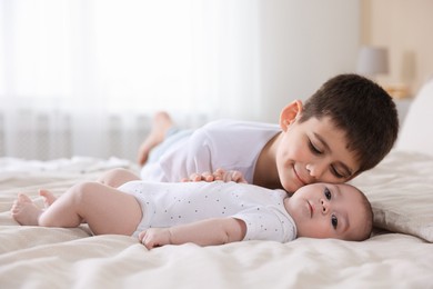 Photo of Cute little brothers on bed at home
