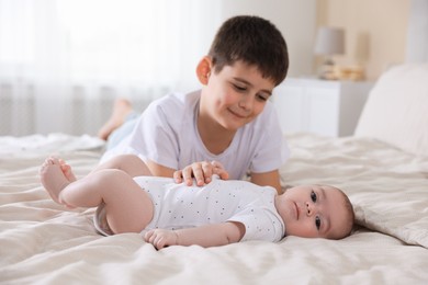 Photo of Cute little brothers on bed at home
