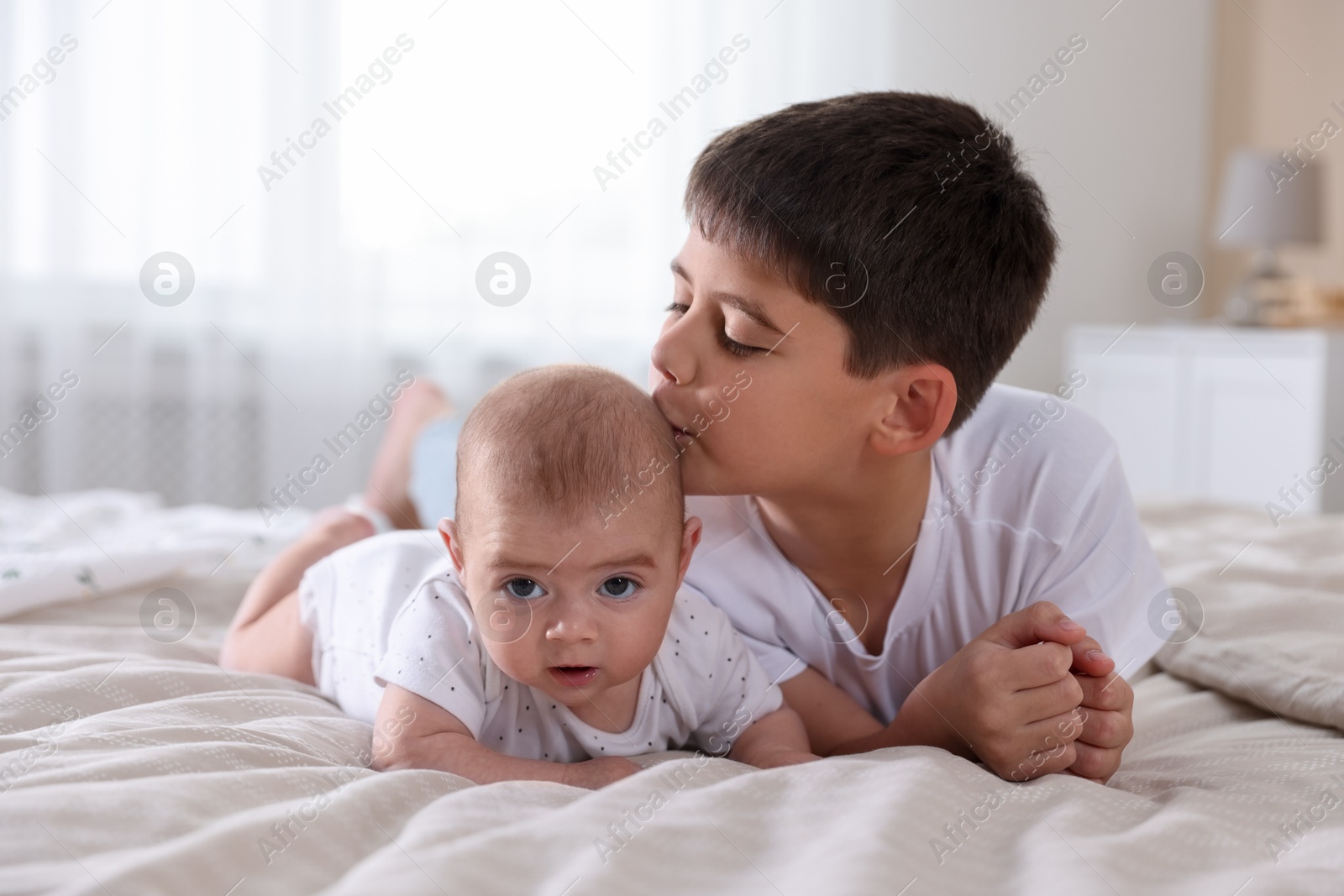 Cute little brothers on bed at home Photo of Cute little brothers on bed at home