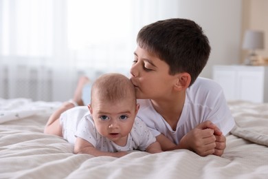 Photo of Cute little brothers on bed at home